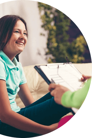 A woman sitting on the couch holding a clipboard.