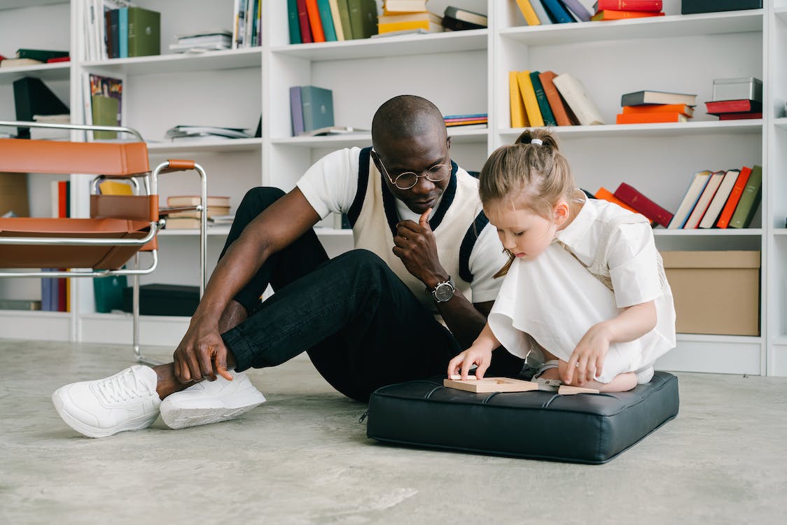 A man and child playing on the laptop.